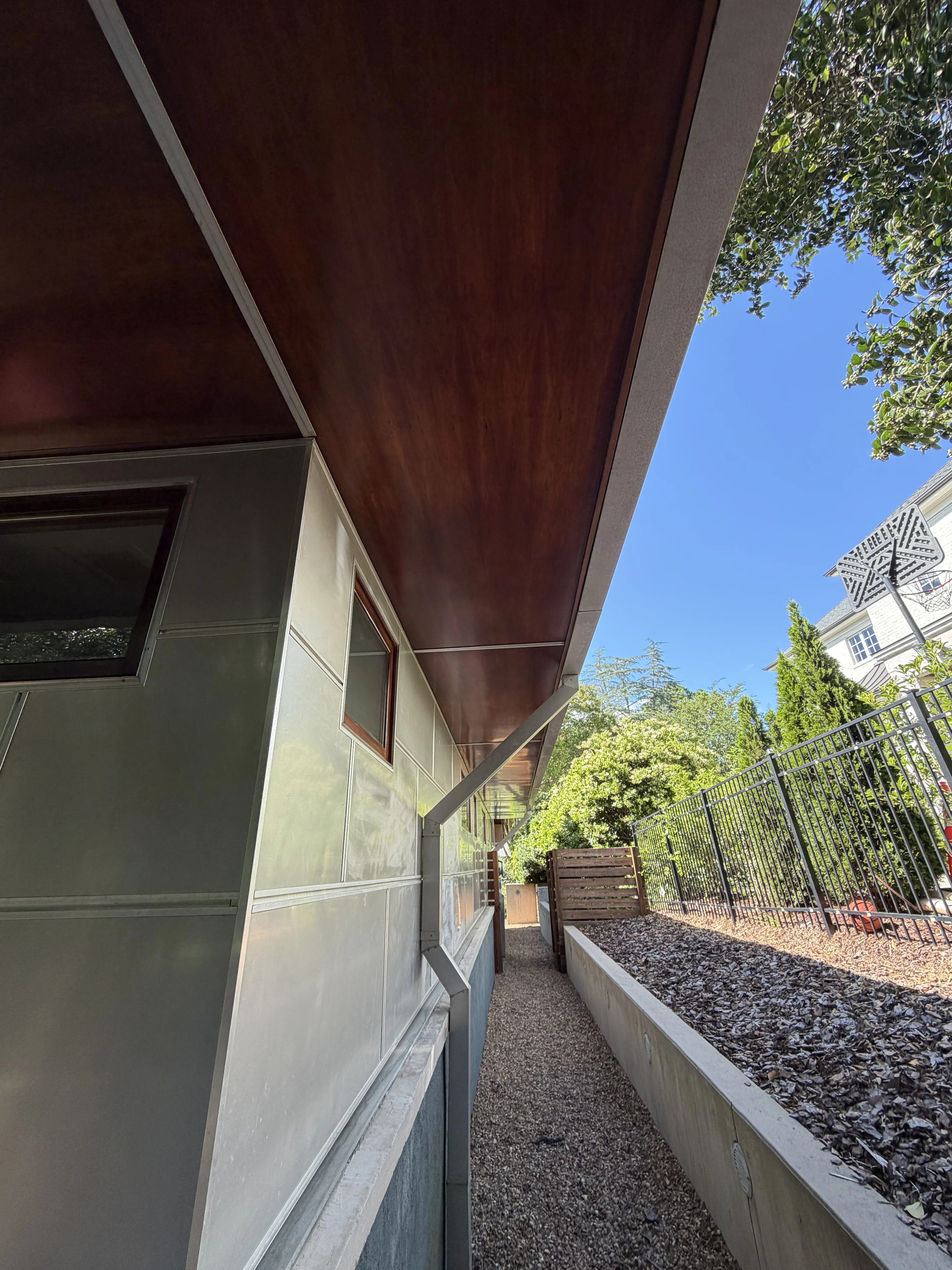Burgundy metal awning with aluminum frame over residential entry with sage trim