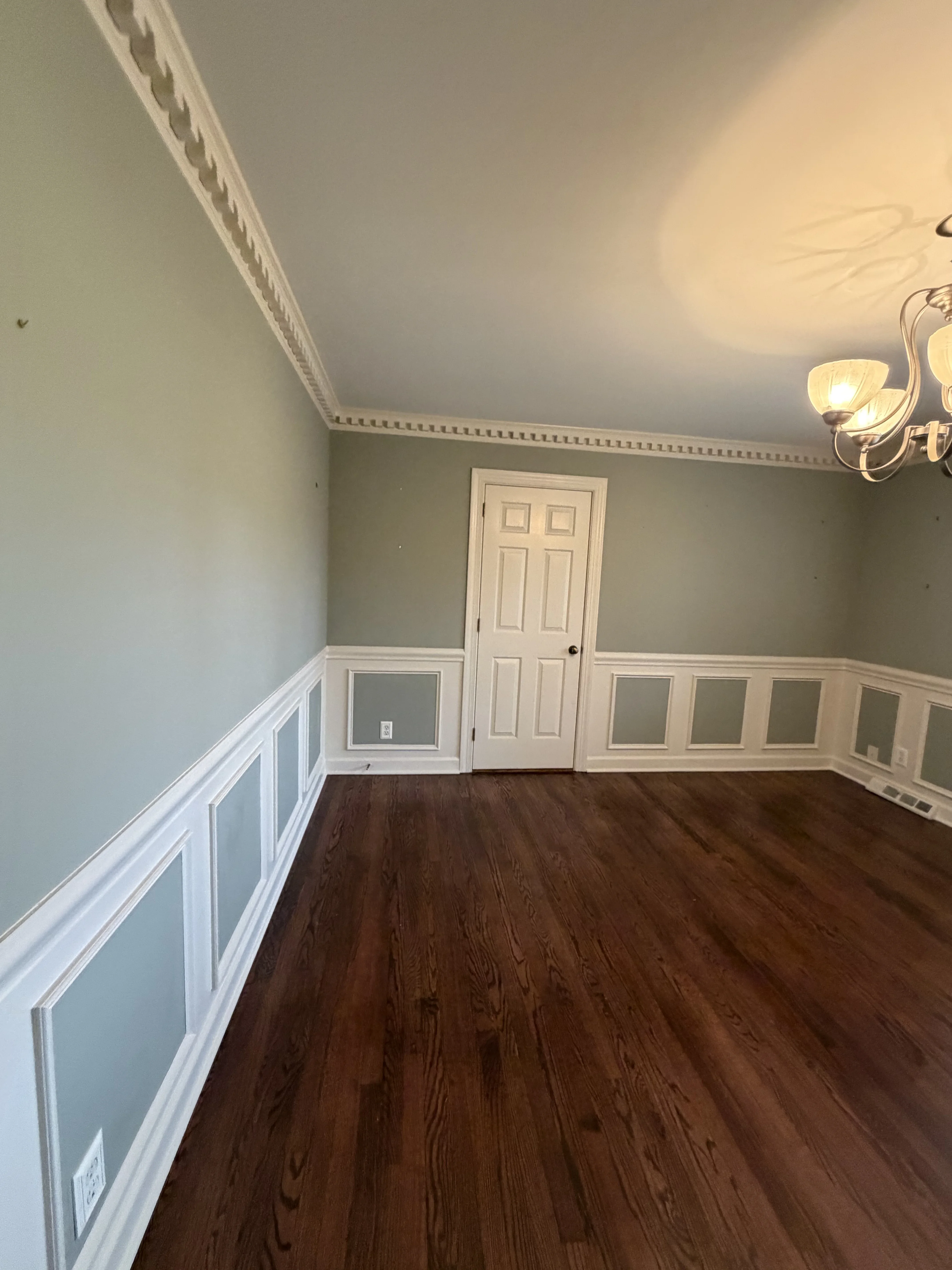 Sage upper walls above white paneled wainscoting and hardwood floors in Charlotte, NC