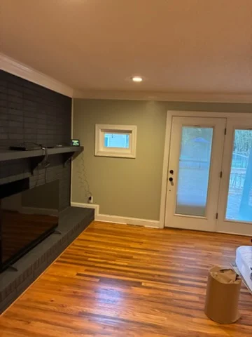 Open Charlotte living space with yellow walls, white door frames, recessed lights, and hardwood